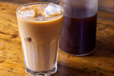 A glass of cold brew coffee, served over ice with cream.