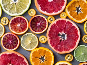 An overhead view of colorful citrus wheels of different sizes an shades of orange, yellow, green, red, and pink.