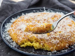 taking a forkful of risotto al salto pancake dusted with grated parmigiano