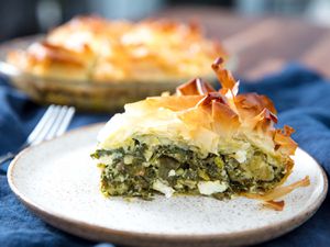 A slice of homemade spanakopita with large chunks of feta inside