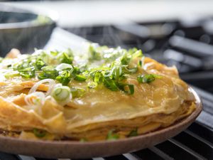 A layered Chinese-style omelette, topped with scallions.