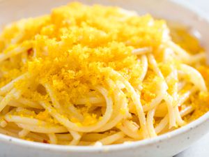 Bottarga grated over a bowl of spaghetti.