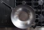 A carbon steel wok on a stovetop