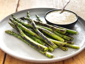 Dry-charred asparagus, served on an earthenware plate with a ramekin of miso bearnaise.