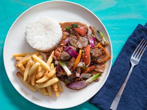 overhead view of lomo saltado plated with french fries and white rice