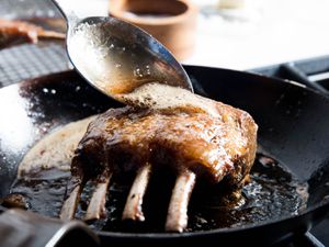 Spooning butter on a pan-roasted rack of lamb. 