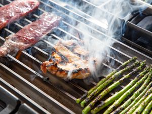 Meat and vegetables cooking on the GrillGrate