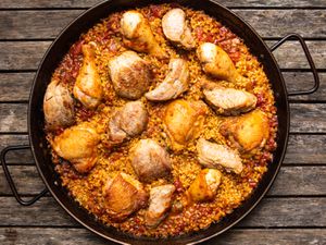 Grilled chicken and pork paella in a paella pan 