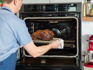 A prime rib roast is removed from an oven.