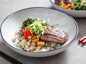 A beefsteak donburi rice bowl topped with scallions