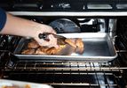 Putting marinated chicken on baking sheet under broiler