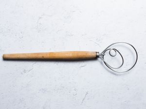 a Danish dough whisk on a white background