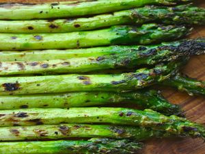 A pile of asparagus spears that have been slightly charred. 