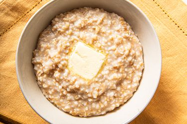 Overhead view of rice cooker oatmeal in a bowl with butter melting into it