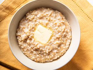 Overhead view of rice cooker oatmeal in a bowl with butter melting into it