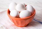 White eggs in an orange bowl.