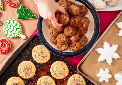 Overhead view of a hand reaching to grab many cookies