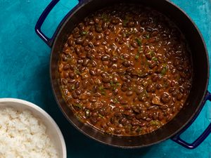 a dutch oven with Kenyan njahi beans in a coconut sauce with a bowl of white rice to the side