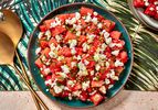 Watermelon, feta, and mint salad in a bowl on a colorful tropical print napkin