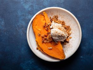 Frozen roasted sweet potato with whipped creme fraiche and granola on a plate.