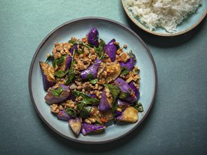 Overhead view of eggplant stir-fry plated on a blue plate on a blue background