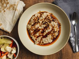 Overhead view of harissa with pickled vegetables and lavash 