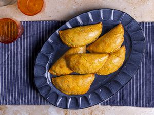 Nigerian meat pies on an ovular serving platter.