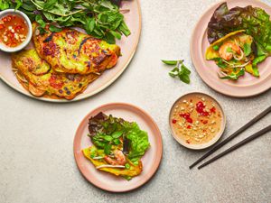 Overhead view of two servings of banh xeo and dipping sauce