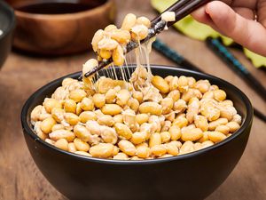 Side angle view of natto being picked up with chopsticks