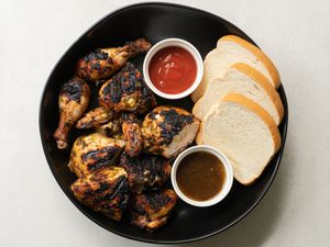 Pan chicken served with white bread and condiments.