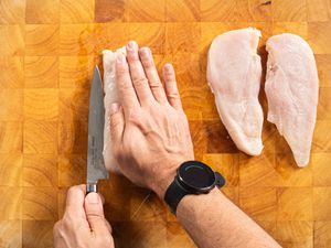 Overhead view of cutting chicken cutlets