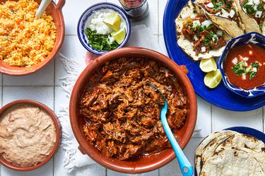 Overhead view of bowl of birria and assorted sides