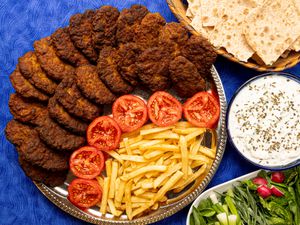 Overhead view of kotlets with tomatoes and french fries