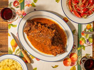 Overhead view of Costillar a la Chilena on a fruit patterened table runner