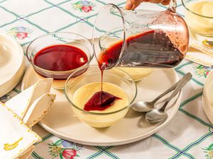 Side view of pouring syrup onto puddings 