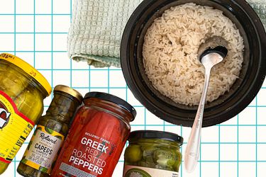 basmati rice in a bowl with a silver spoon accompanied by jars of brined vegetables