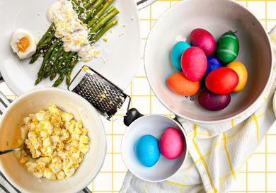 A composed image of colorful Easter eggs, egg salad, and asparagus with yogurt sauce and grated eggs