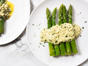 A plate of blanched asparagus dressed with creamy sauce gribiche.