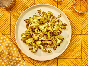 Overhead view of airfryer cauliflower on an orange table setting