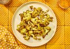 Overhead view of airfryer cauliflower on an orange table setting