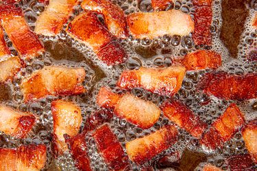 Overhead view of lardons cooking in skillet