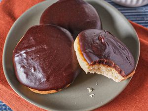 3 cookies on a grey plate, one cookie has bite marks taken out of it. Plate is on red napkin on a blue tablecloth 