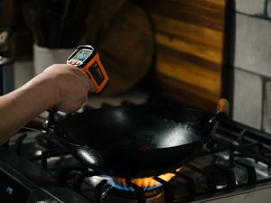 A thermometer pointed at a wok