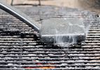 Cleaning a grill grate with a steel brush. 