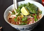 A bowl of Faux Pho, garnished with cilantro, bean sprouts, and a lime wedge.