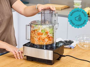 A person using a food processor to make mirepoix.