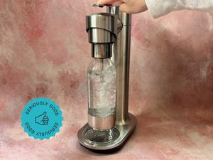 A person carbonating water with the Breville soda maker.