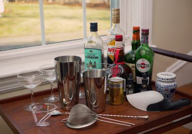 a bar cart with gear and bottles of liquor on it