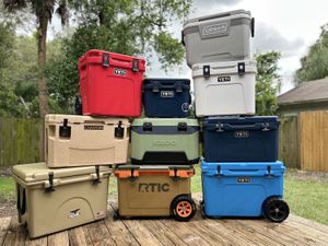 A number of coolers stacked on top of each other in a backyard.