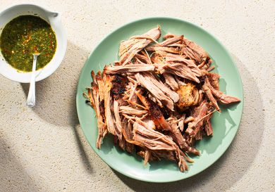 Overhead view of Cuban-Style Roast Pork Shoulder With Mojo, served on a seafoam colored platwe.